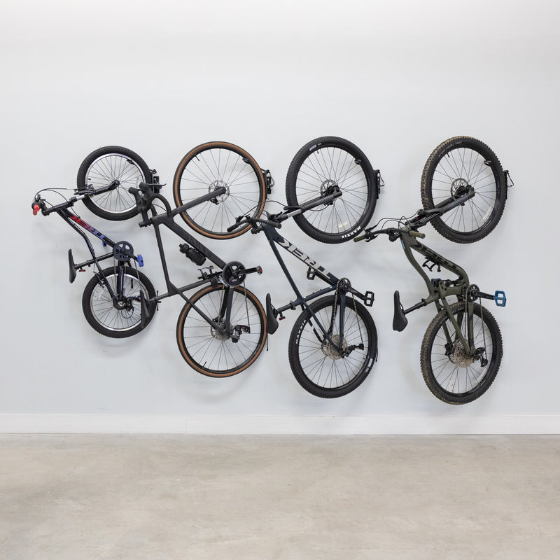 Four bikes hanging on swivel wall hooks