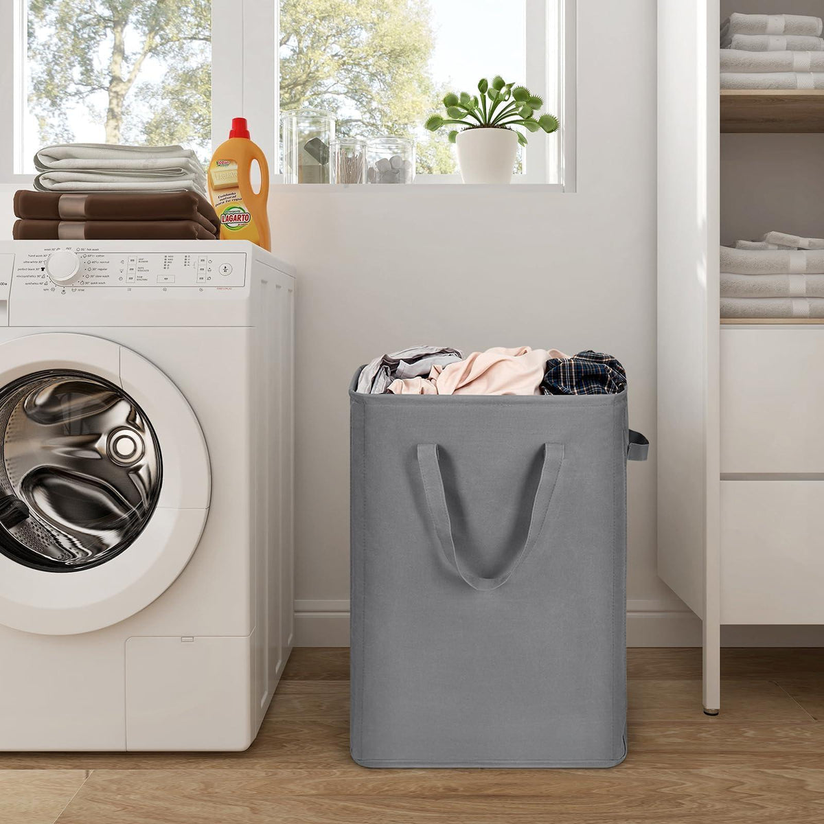 Gray slim laundry hamper standing beside a washing machine