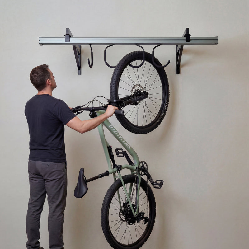Man hanging a bike on the wall-mounted CycleSlide track