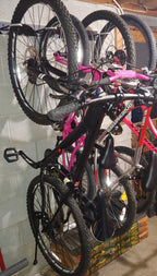 Close-up of several bikes hanging on the wall rack