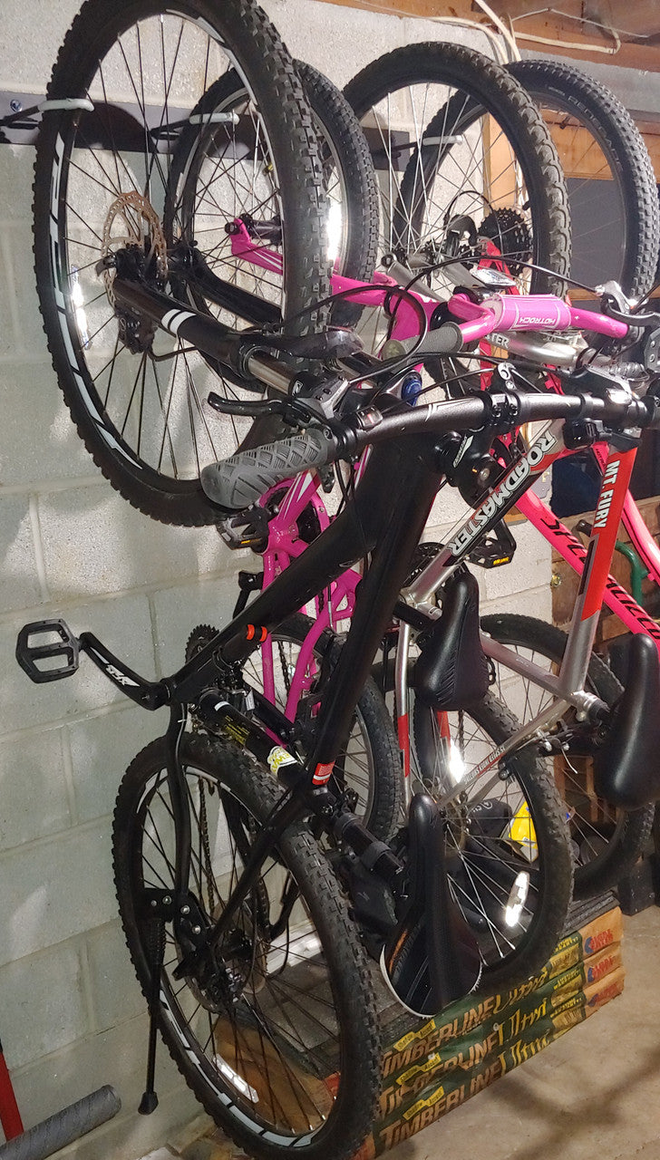 Close-up of several bikes hanging on the wall rack