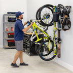 Man hanging a bike on the G-Adventure wall rack in a garage