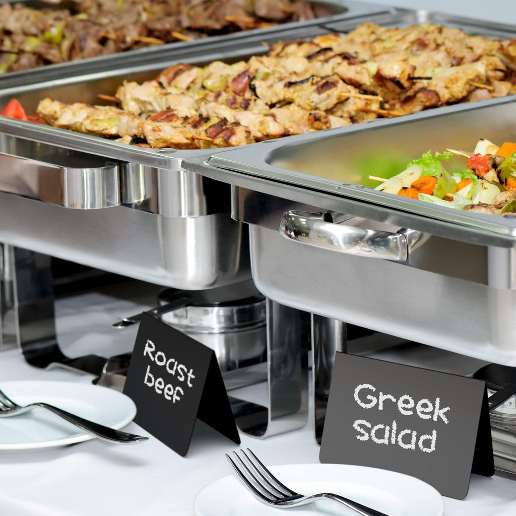 Black chalkboard tent signs labeling food at a buffet