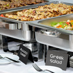 Black chalkboard tent signs labeling food at a buffet