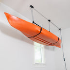 Orange kayak stored near the ceiling on the hoist