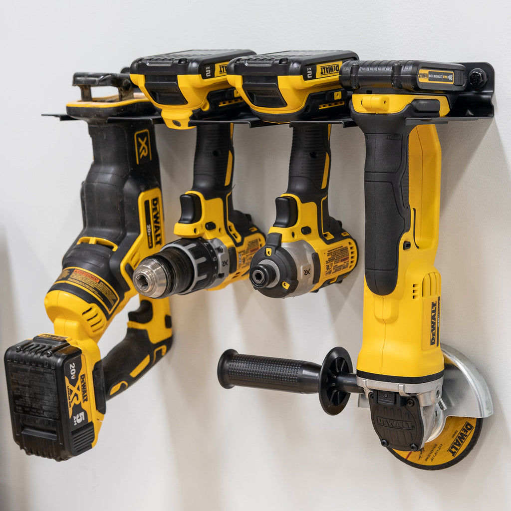 Four yellow cordless tools stored in the rack, angled view