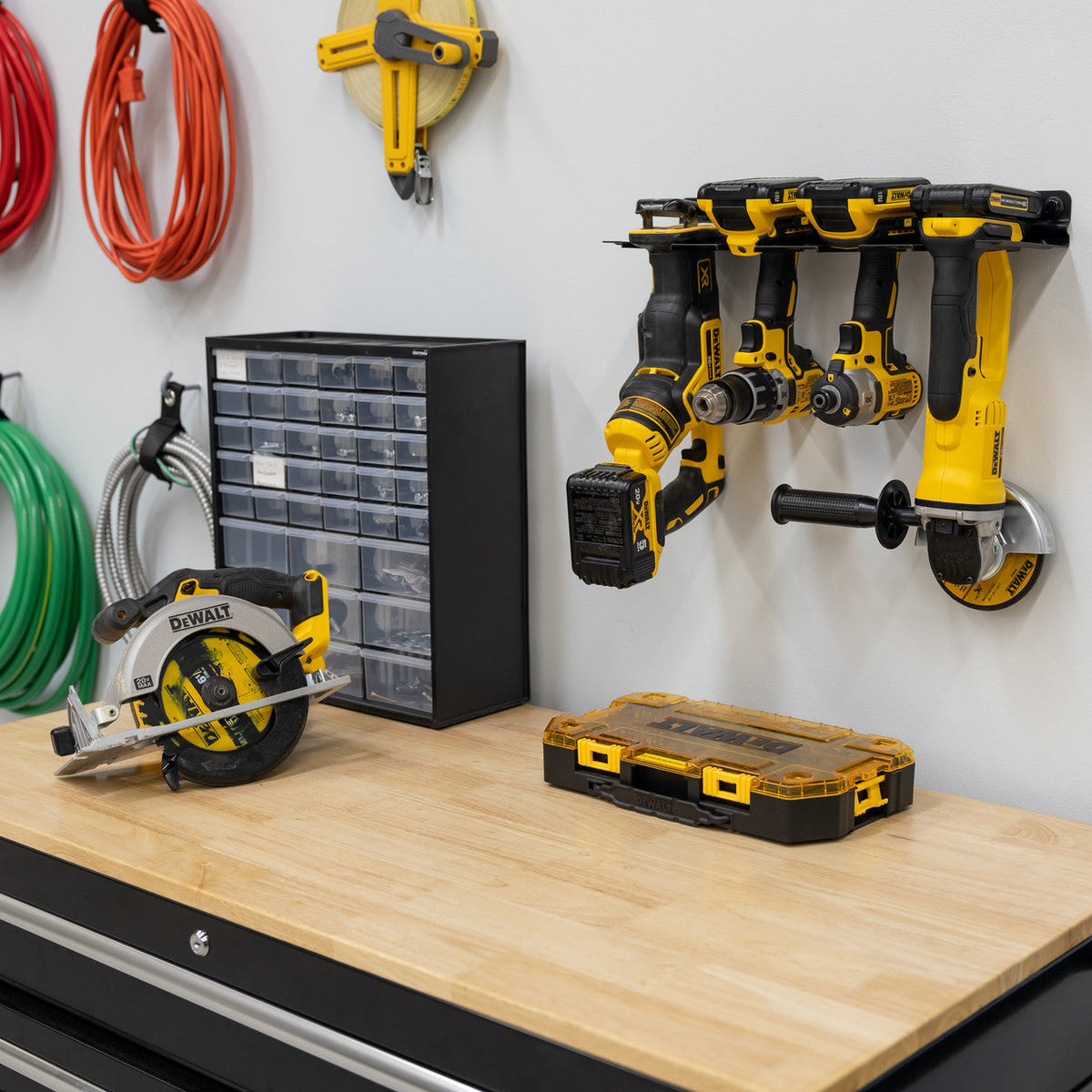 Power tool organizer above a workbench with a circular saw, parts drawer and cords