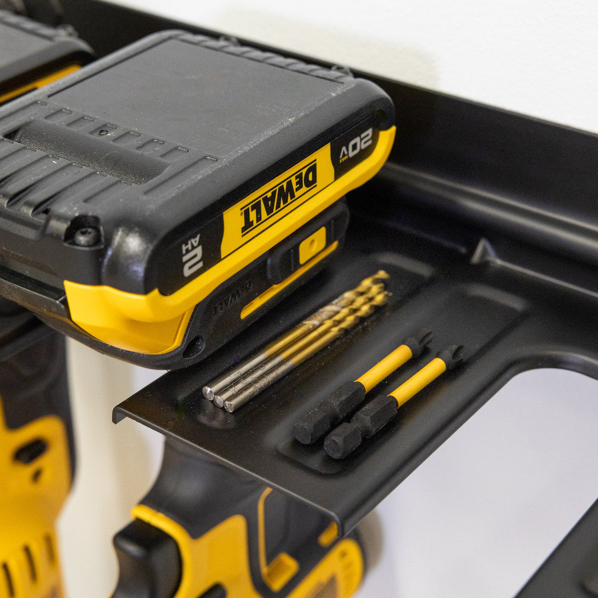 Close-up of a battery and drill bits resting on the organizer rack