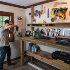 Man hanging a tool in a workshop with the power tool organizer on a pegboard
