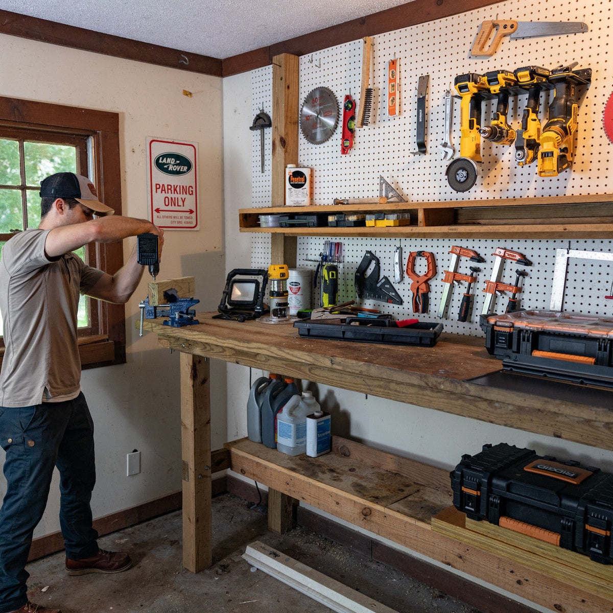 Man hanging a tool in a workshop with the power tool organizer on a pegboard