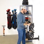 Person storing a hitch cargo rack on the hitch wall mount next to garage shelving