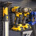 Drills and a work light stored on pegboard accessory holders