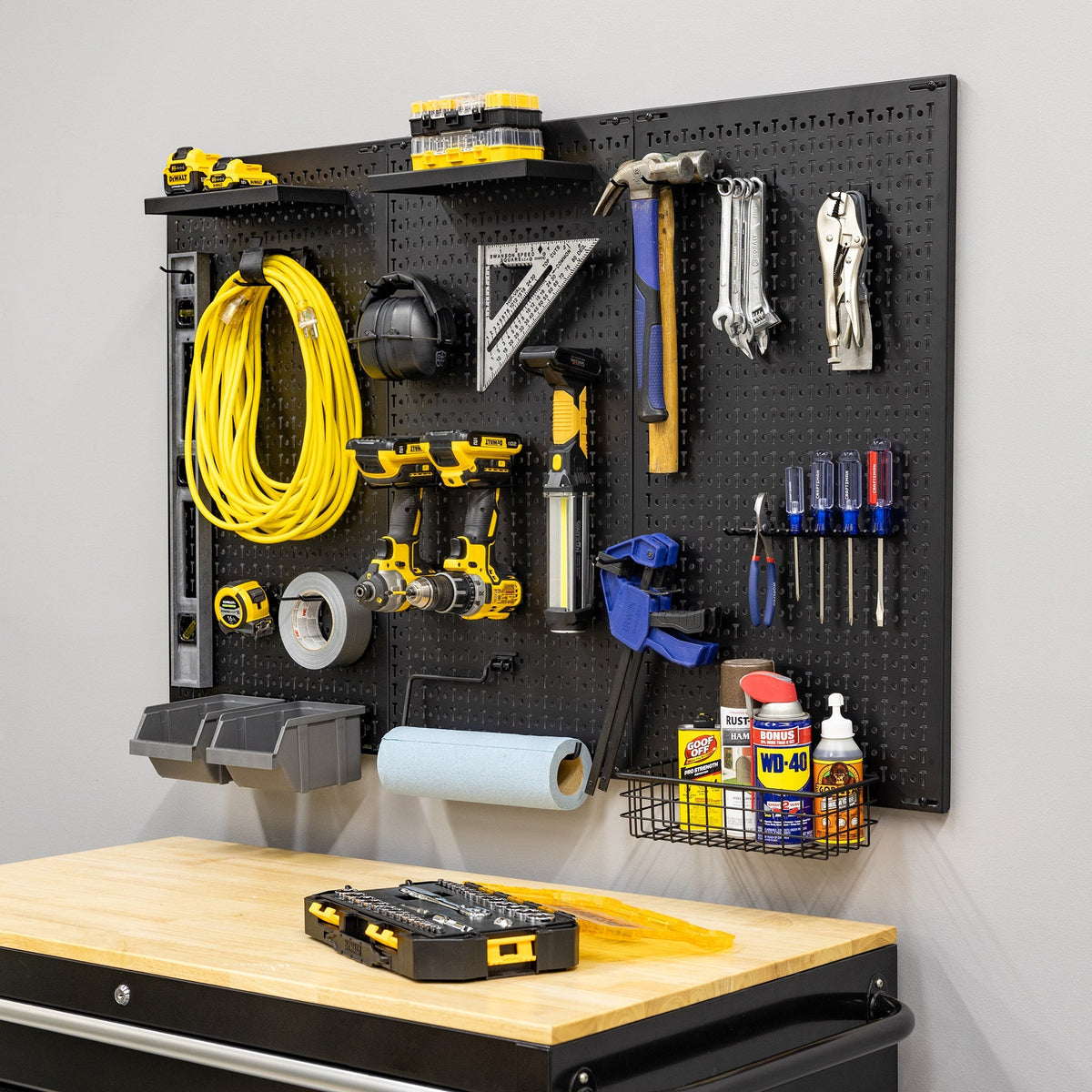 51 x 32 inch pegboard with an extension cord, hand tools, drills, bins and a basket above a workbench