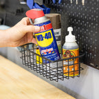 Hand placing a spray can into the pegboard wire basket