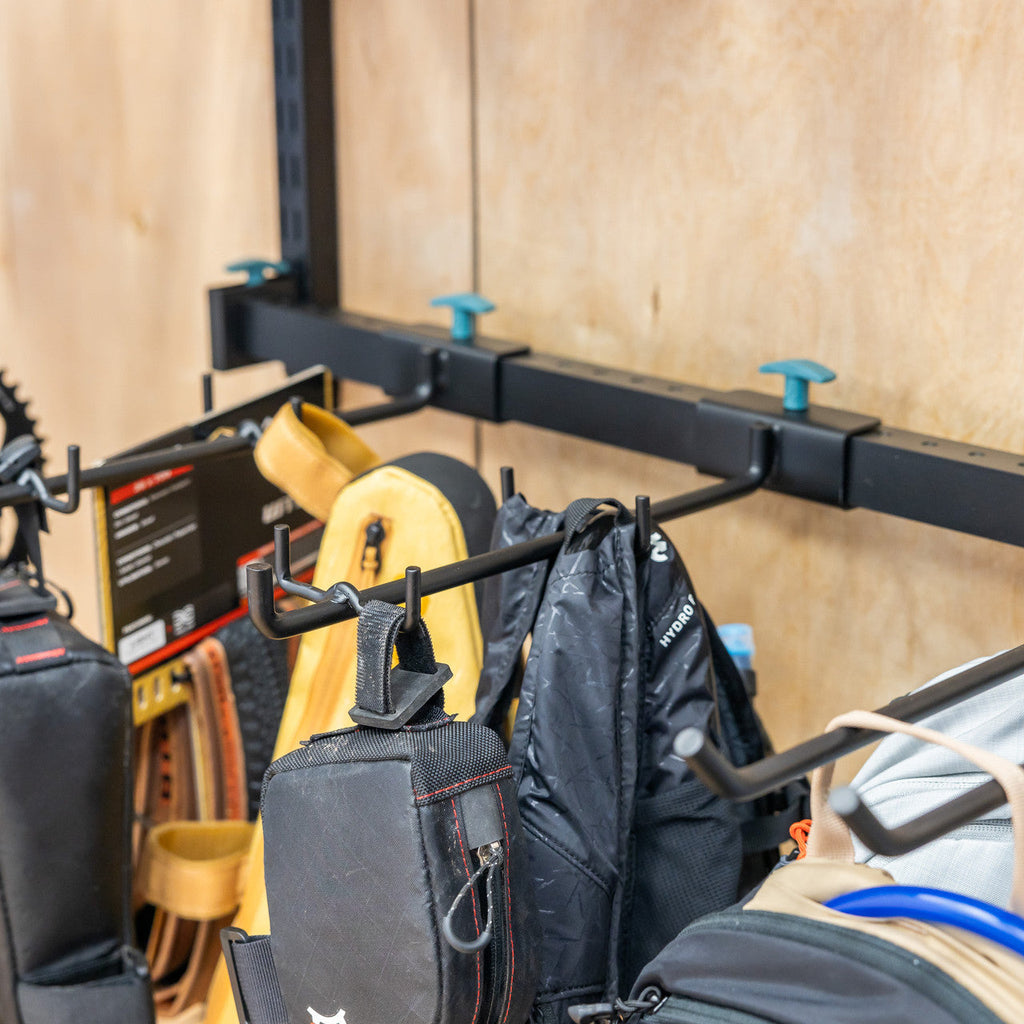 Close-up of bags and a backpack hanging on the rail hooks