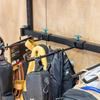 Close-up of bags and a backpack hanging on the rail hooks