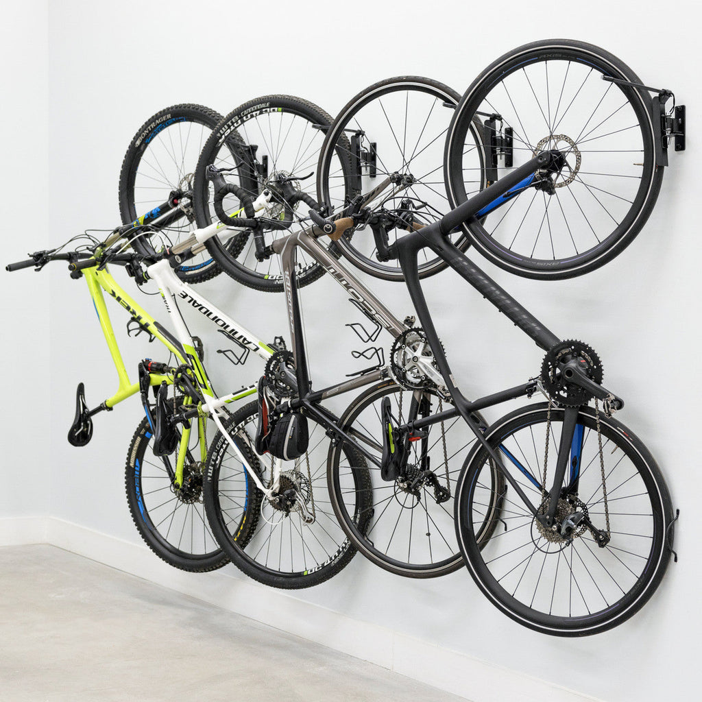 Four bikes on swivel wall hooks, angled view