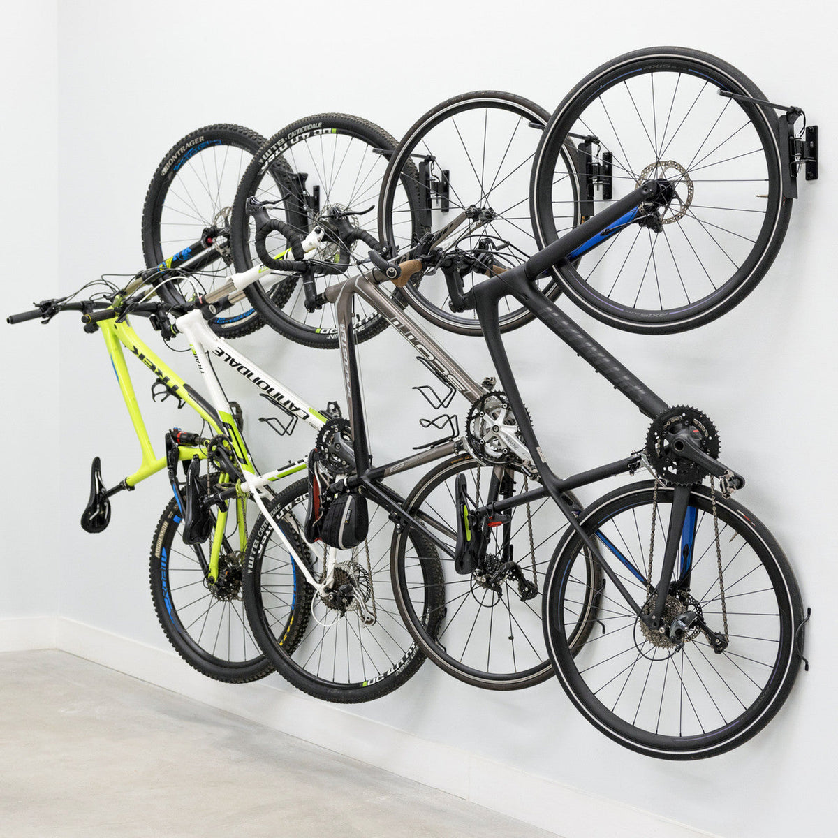Four bikes on swivel wall hooks, angled view