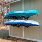 Two kayaks stored on the Shenandoah 2-level rack on an outdoor shed wall