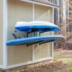 Kayak and paddleboard stored on the shed wall rack