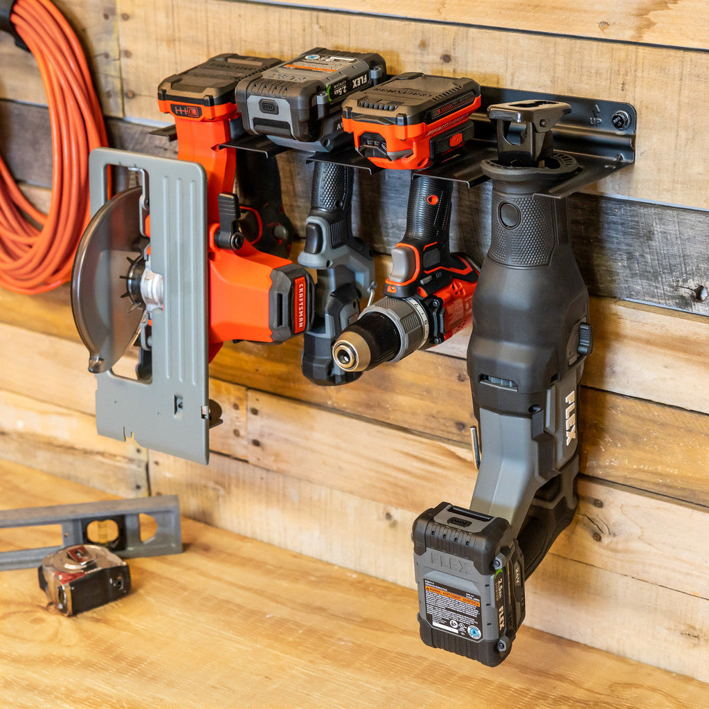 Close-up of cordless tools hanging in the organizer on a wood wall