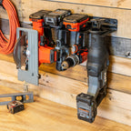 Close-up of cordless tools hanging in the organizer on a wood wall