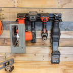 Power tool organizer on a wood wall holding a circular saw, drills and a reciprocating saw