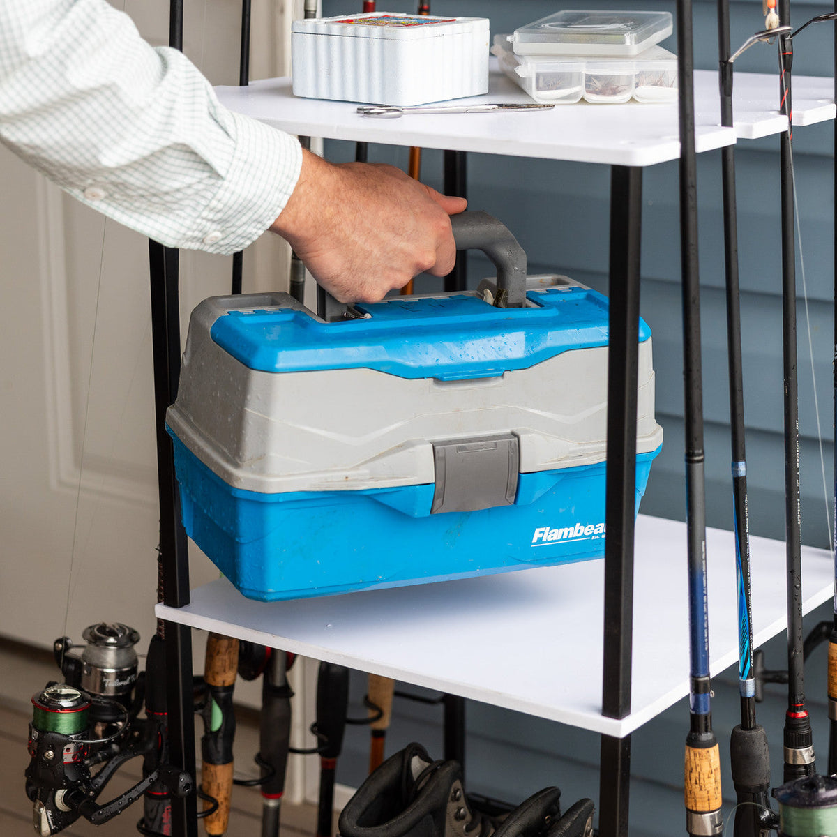 Hand placing a tackle box on the rod stand shelf