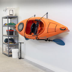 Orange kayak and paddle stored on the Roanoke Pro wall rack in a garage