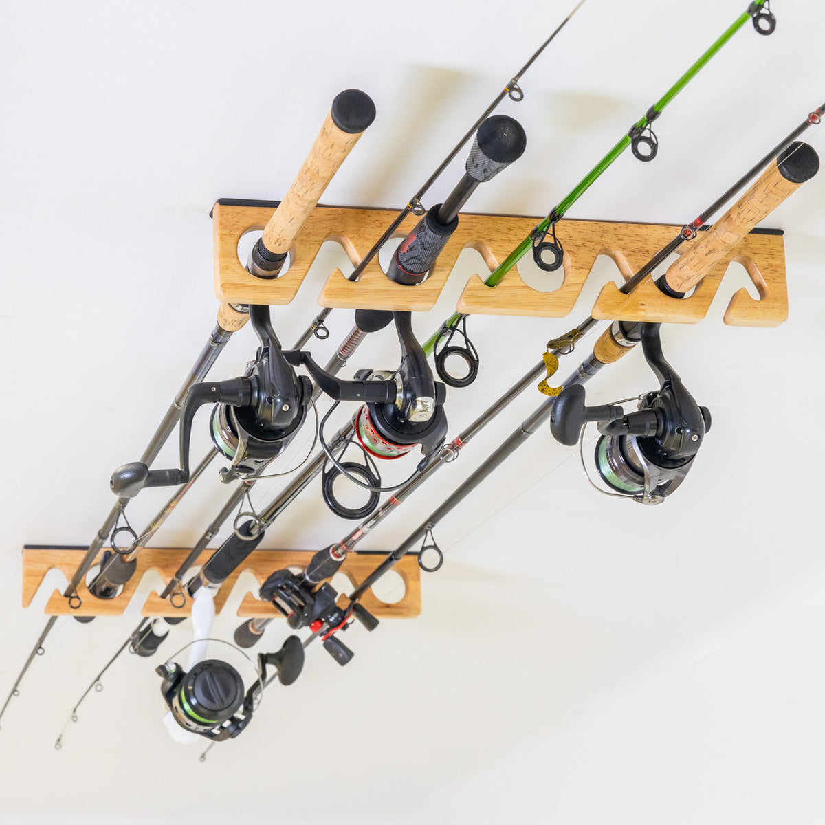 Fishing rods stored horizontally on the wood rack, angled view