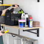 Person taking supplies from a wood shelf on DIY brackets