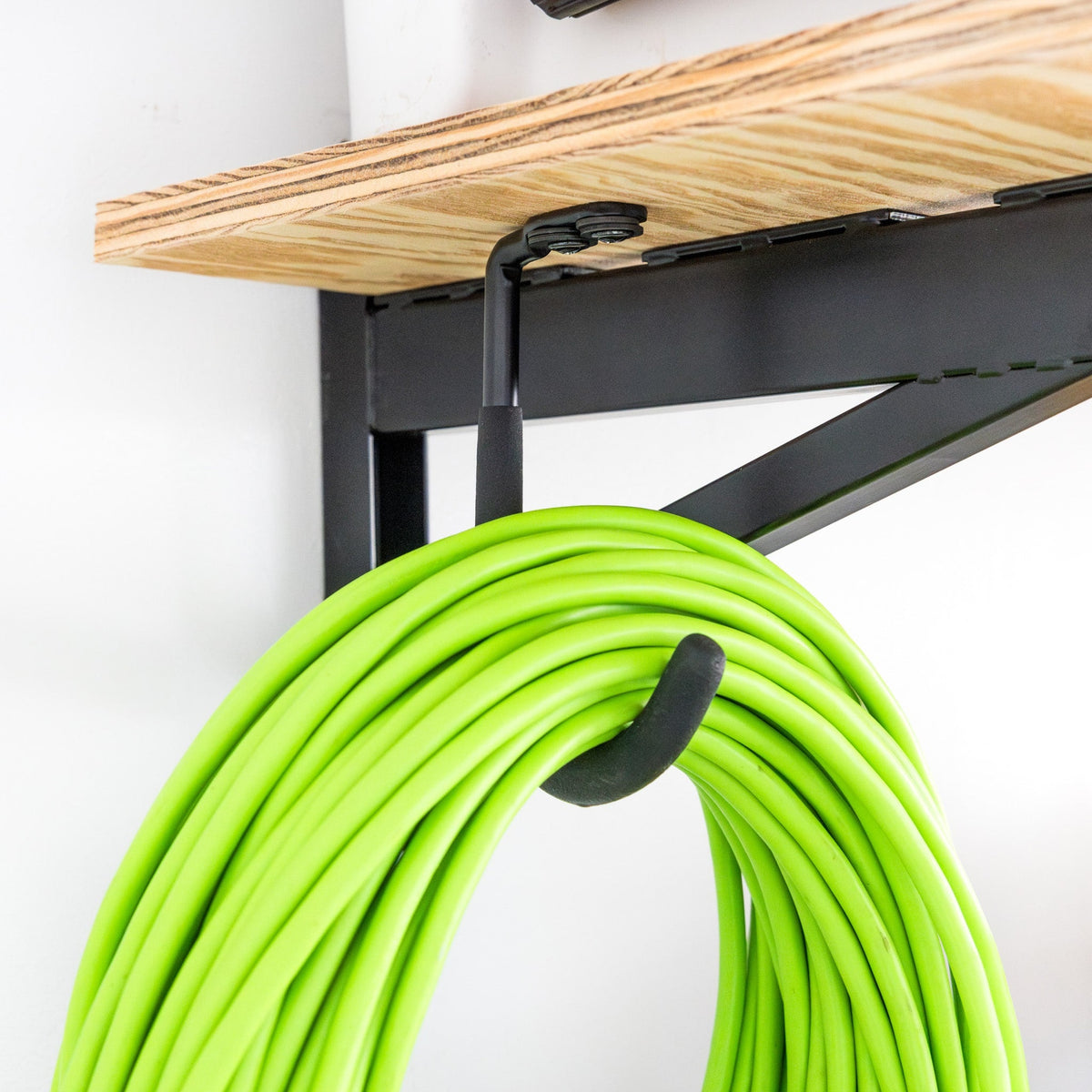 Close-up of an extension cord hanging on the DIY bracket hook