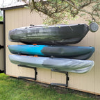 Three kayaks stored on the outdoor 4-level rack on a shed