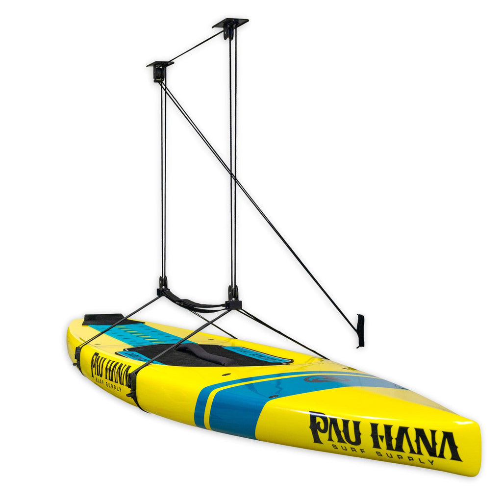 Yellow paddleboard lifted by the garage pulley hoist