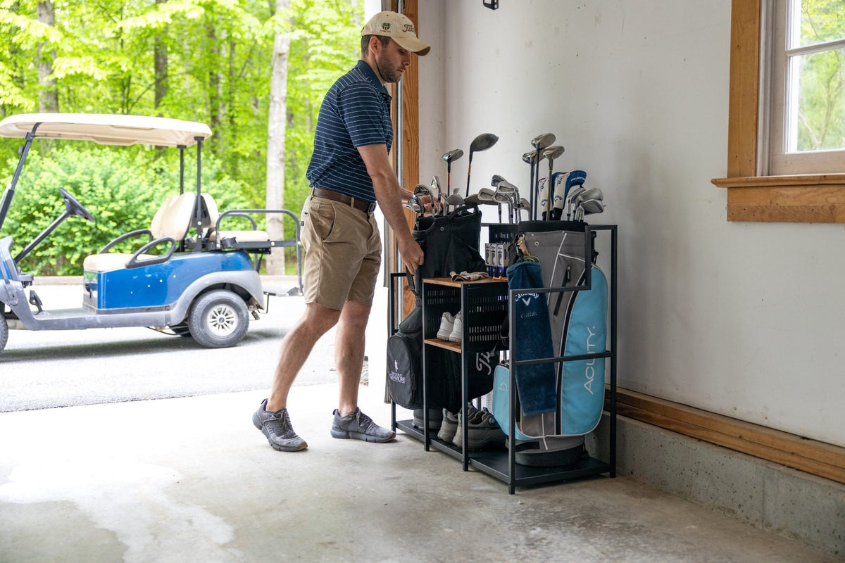 Man walking to the golf organizer in a garage with a golf cart outside