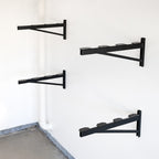 Four black 2 x 4 ft DIY shelf brackets mounted on a wall without shelves