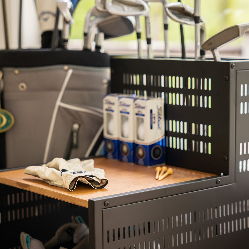 Golf balls, gloves and tees on the organizer shelf beside a golf bag