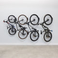Four bikes hanging on swivel wall hooks