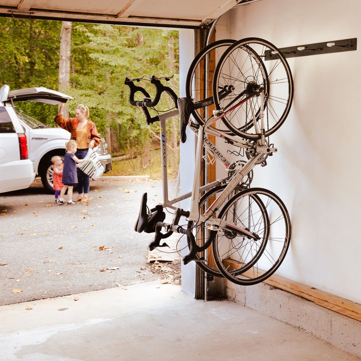 Bikes stored on the 4-bike wall rack inside an open garage