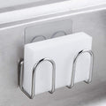 Stainless steel adhesive sponge holder mounted inside a sink and holding a white sponge