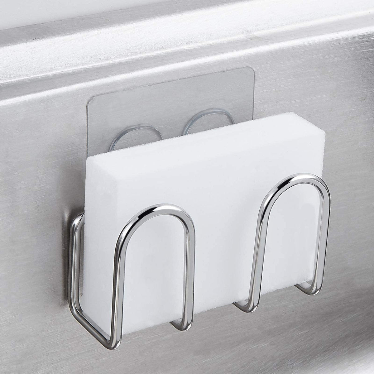 Stainless steel adhesive sponge holder mounted inside a sink and holding a white sponge