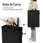 Black laundry hamper carried by its long reinforced handles