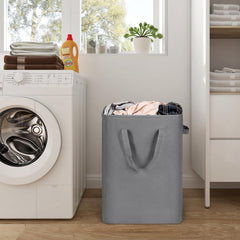 Gray slim laundry hamper standing beside a washing machine