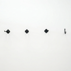 Row of small Simple Hooks on a white wall