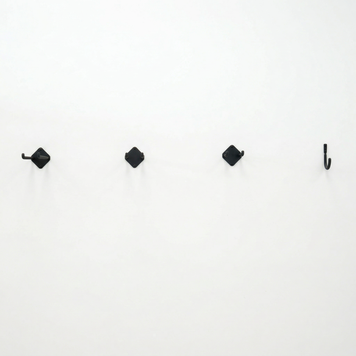 Row of small Simple Hooks on a white wall