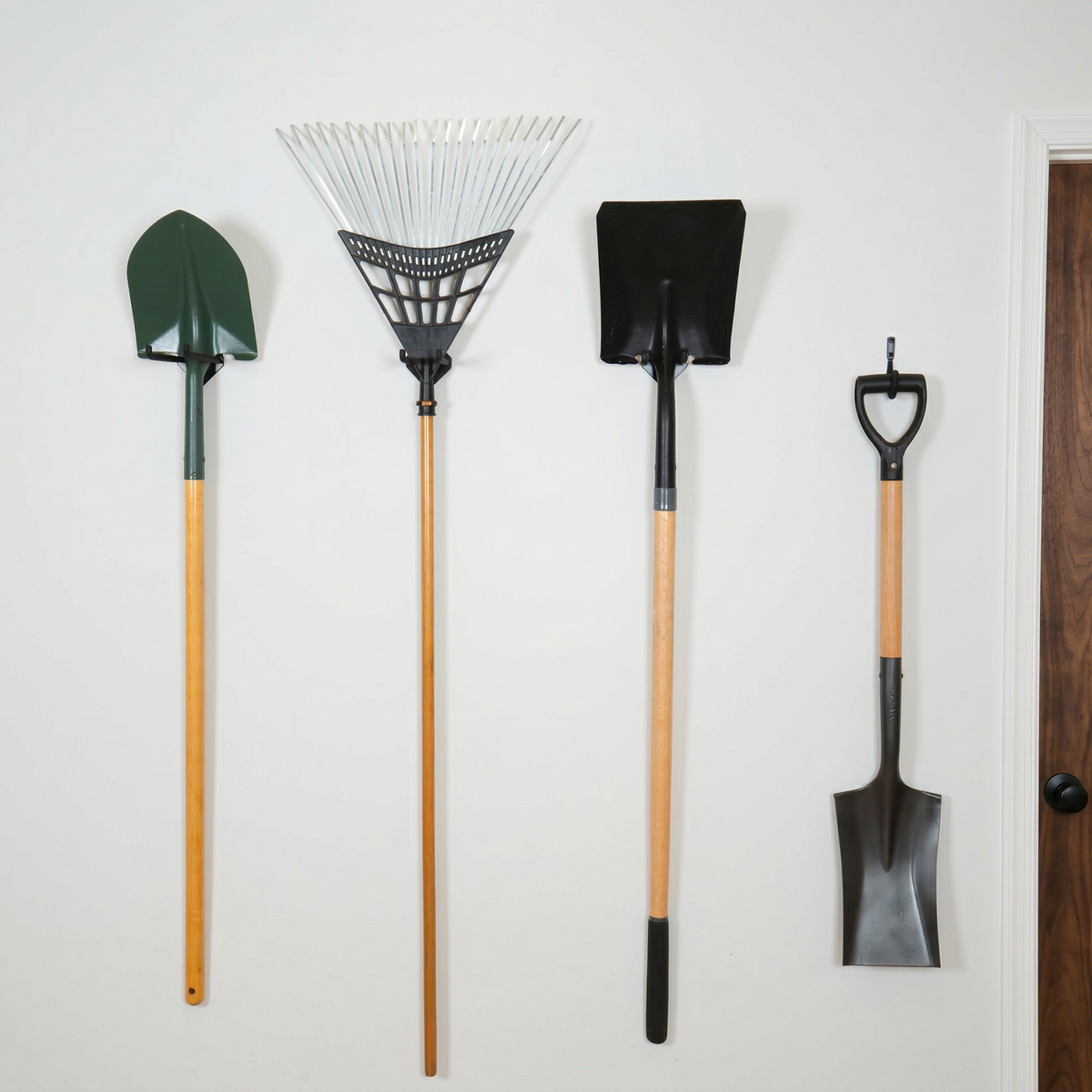 Four yard tools hanging on Simple Hooks on a white wall