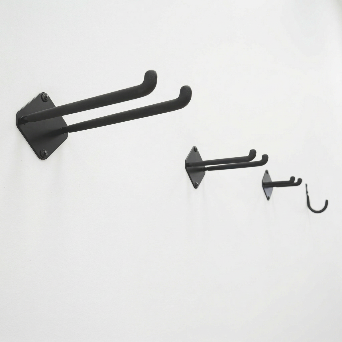Large, medium and small double hooks and a mini J hook mounted on a wall