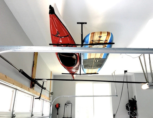 Kayaks stored on the ceiling rack above a garage door track