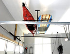 Kayaks stored on the ceiling rack above a garage door track