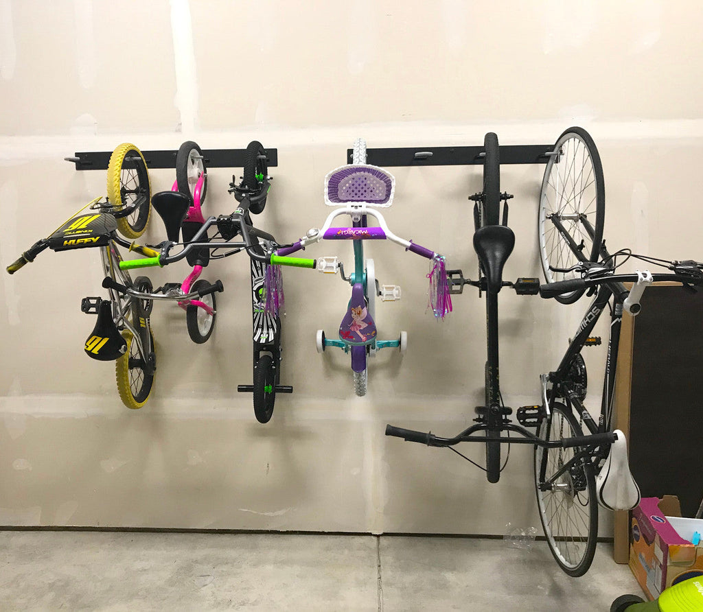 Kids and adult bikes hanging on Blackstone racks along a garage wall